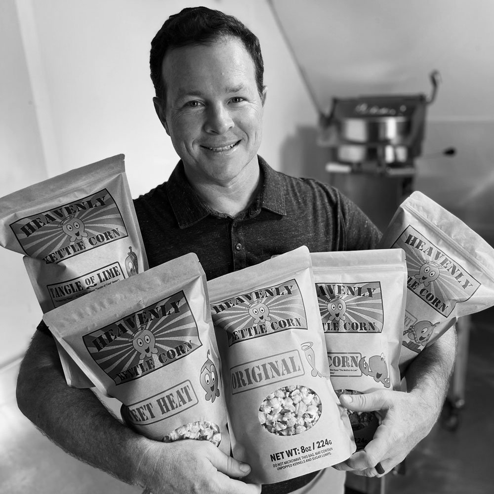 Heavenly Kettle Corn - Our Story - Owner, Jeremy holding bags of gourmet kettle corn.